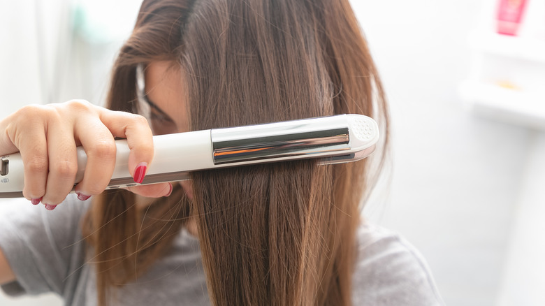 Person using straightener on hair