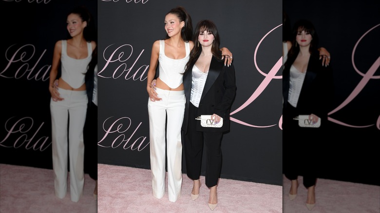 Nicola Peltz Beckham and Selena Gomez smiling as they wear white corsets at the premiere of "Lola"