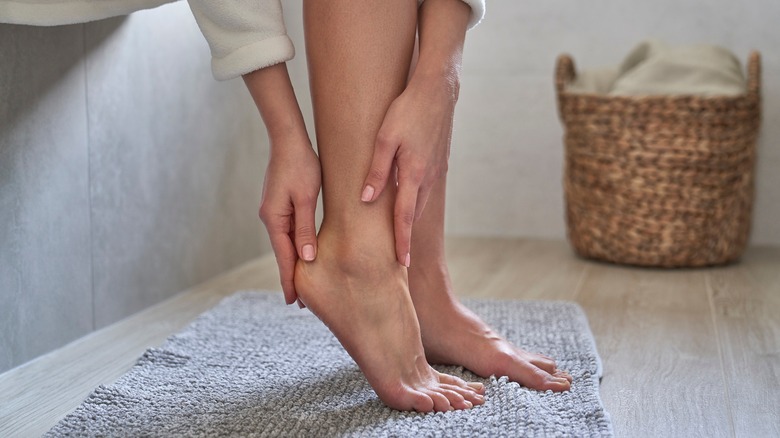 A woman moisturizing her feet