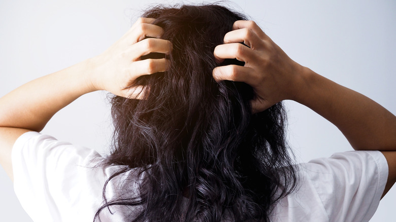 Woman with hands in damaged hair