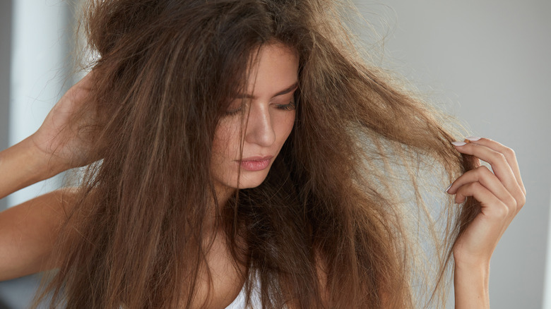Woman touching her frizzy hair