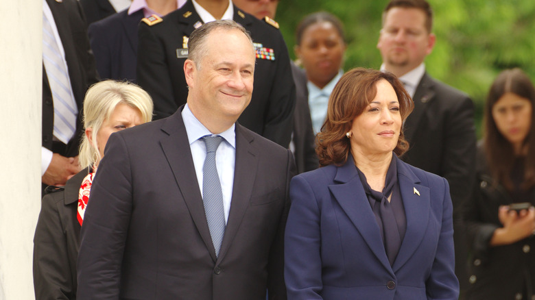 Doug Emhoff and Kamala Harris standing together in coats