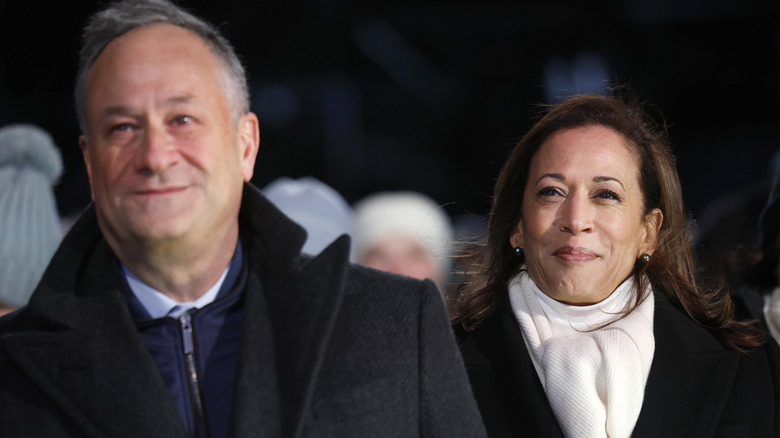 Doug Emhoff and Kamala Harris standing together in coats