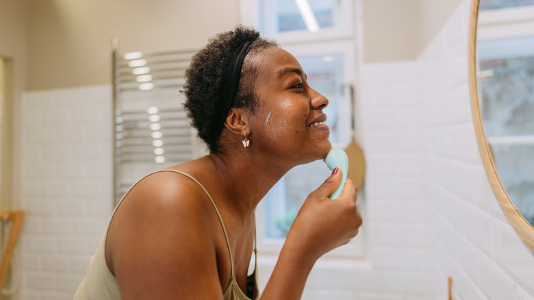Woman washing face with exfoliator