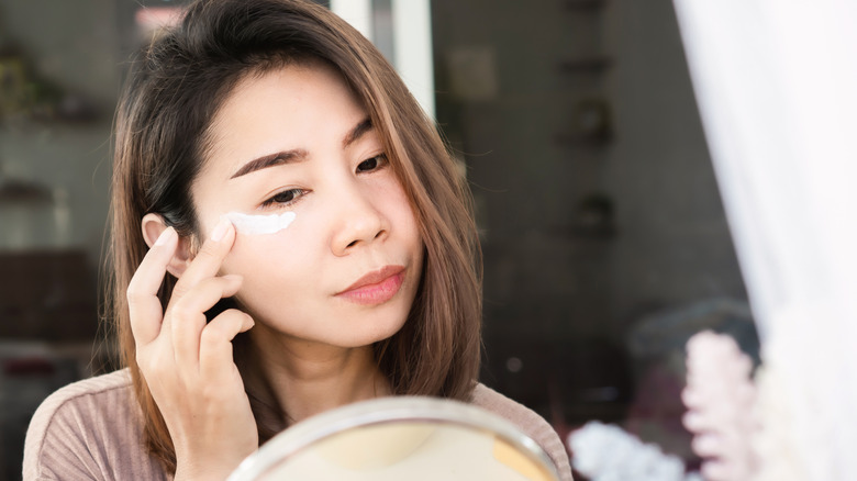 Woman applying under eye cream