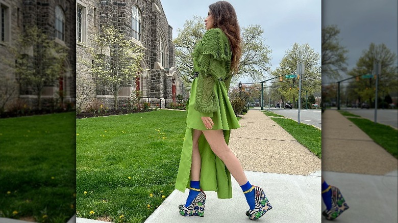 Woman walking in green dress and bold shoes