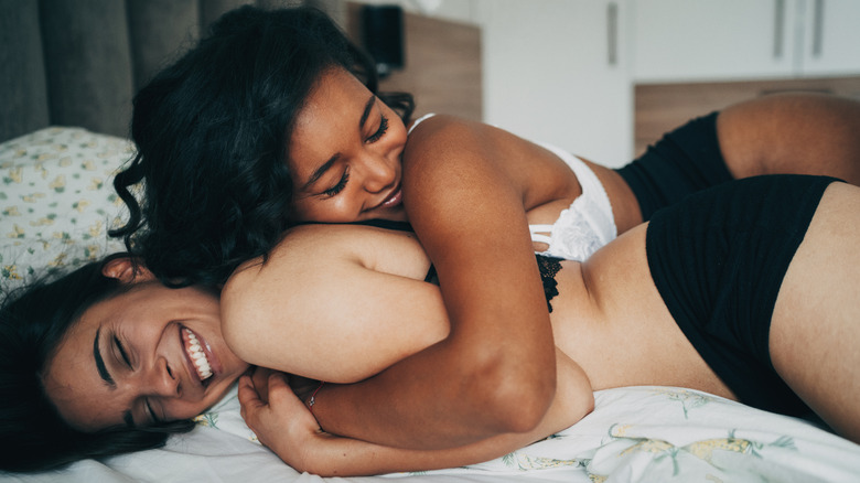 Two women cuddling in bed
