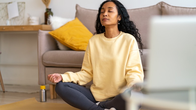 woman meditates in living room