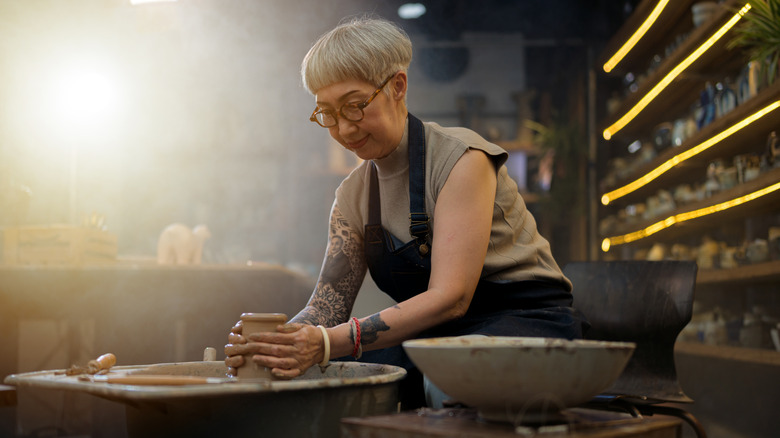 Older woman with tattoos in pottery class