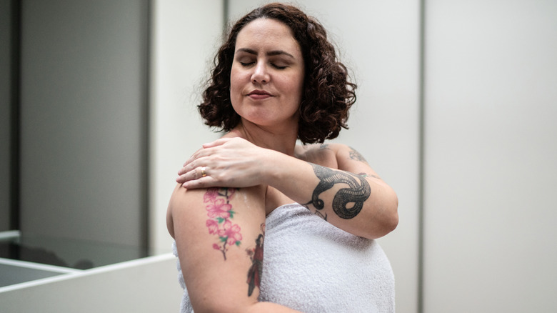 Woman in towel washing her tattoo