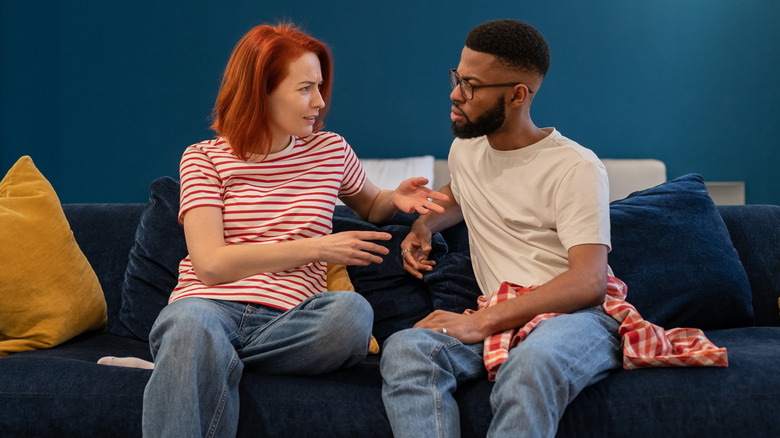 Woman and man sitting on couch talking seriously