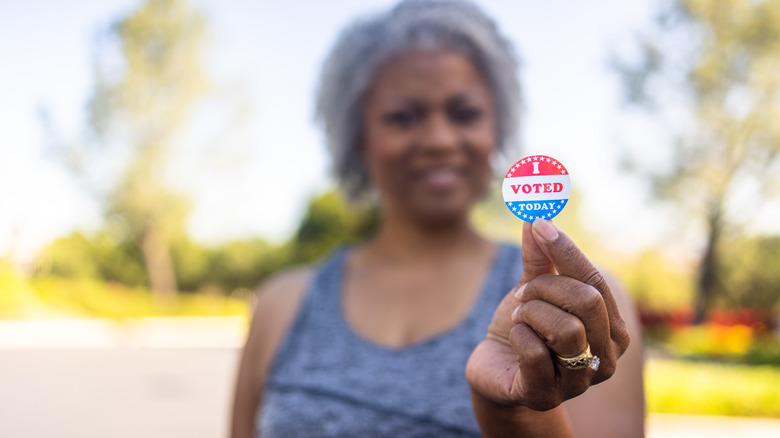 Woman holding "I voted" sticker