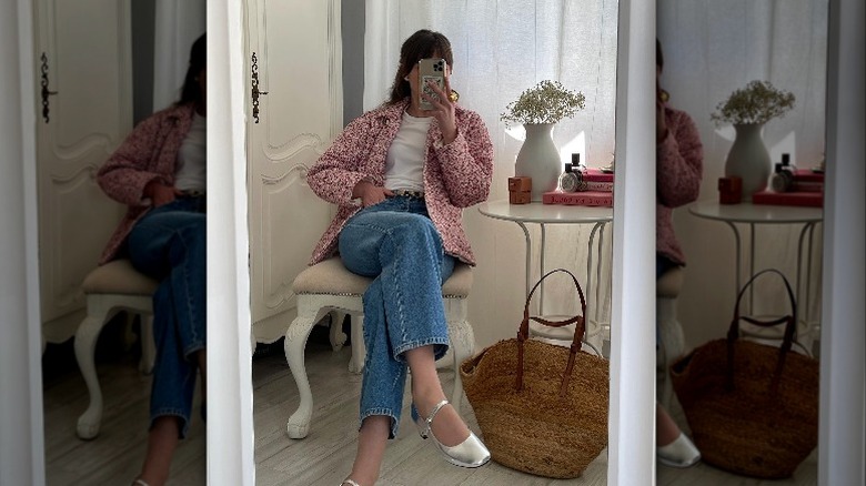 Woman sitting in chair taking mirror selfie