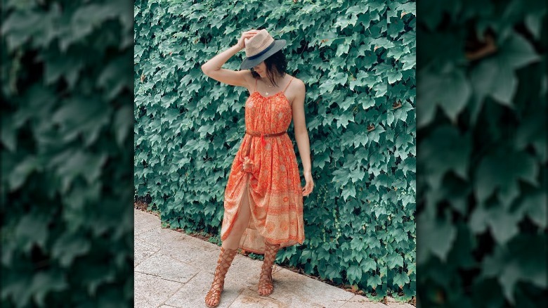 Woman in orange dress and brown gladiator sandals 