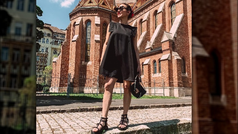 Woman in black dress with black gladiator sandals