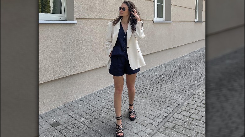Woman in gladiator sandals and white blazer