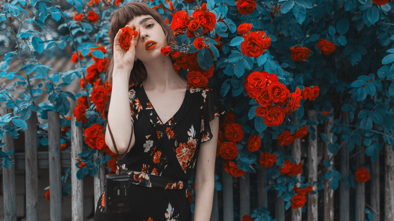 woman posing by roses