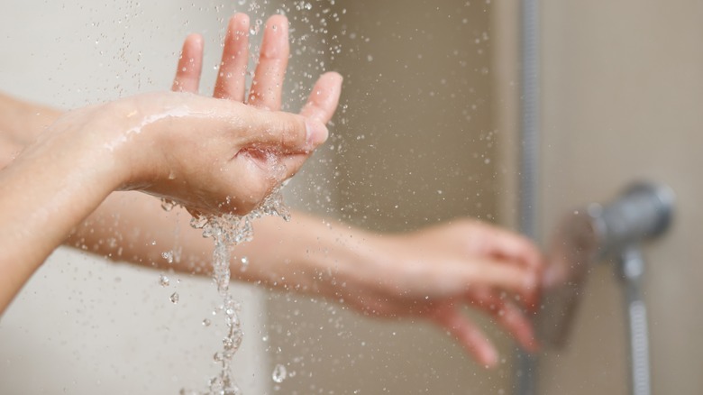 Person touching a shower dial