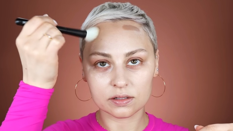 Woman contouring her forehead