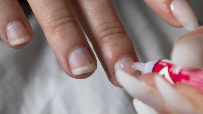 woman applying nail glue
