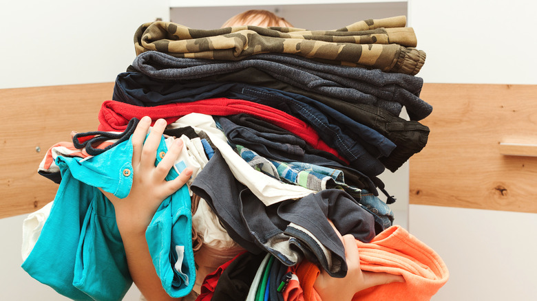 Person holding a pile of clothing 