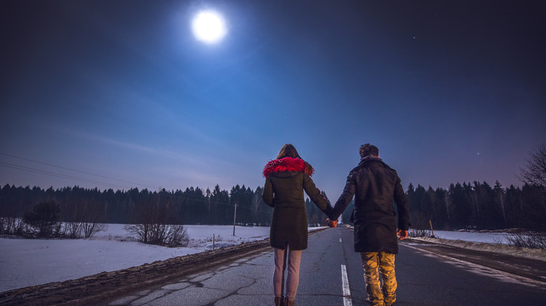 Couple walking on a moonlit road