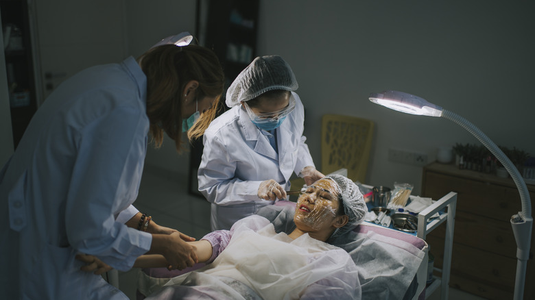 Doctors conducting facial surgery 