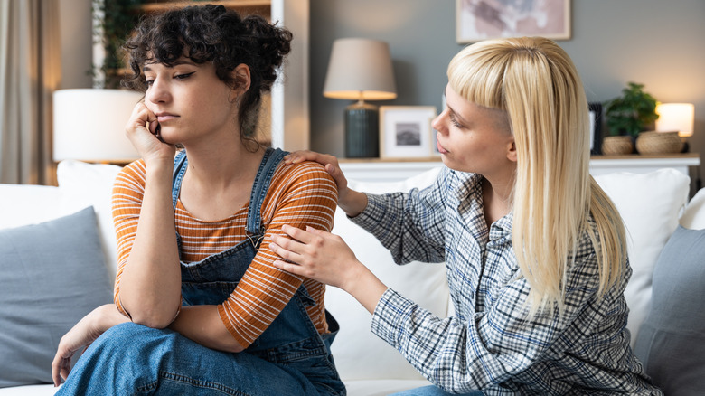 two women arguing on a couch