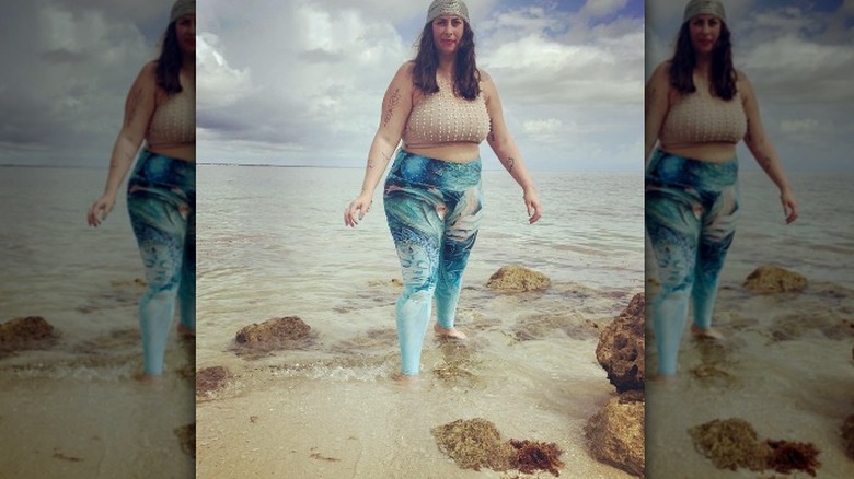 Woman on beach, pearls and leggings