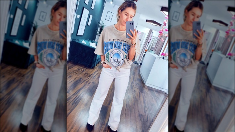 Woman taking selfie in tee with white jeans