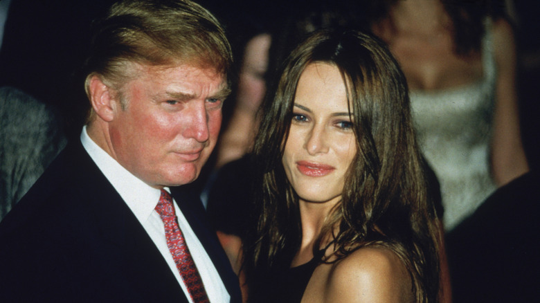 Melania Trump in a sleeveless dress and Donald Trump in a suit at an event