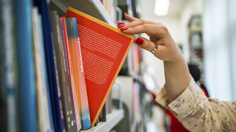 woman's hand picking a book