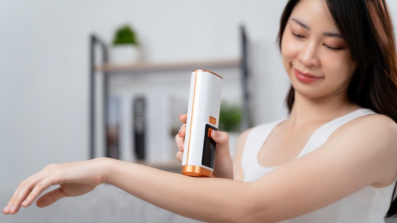 Woman using an epilator on her arm