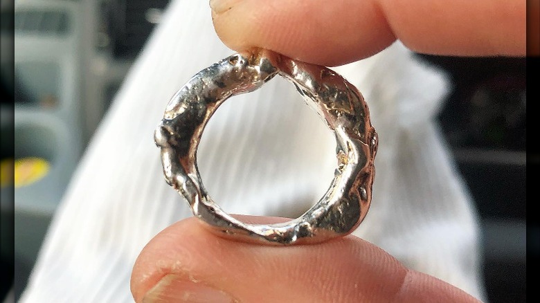 jeweler holds molten silver ring