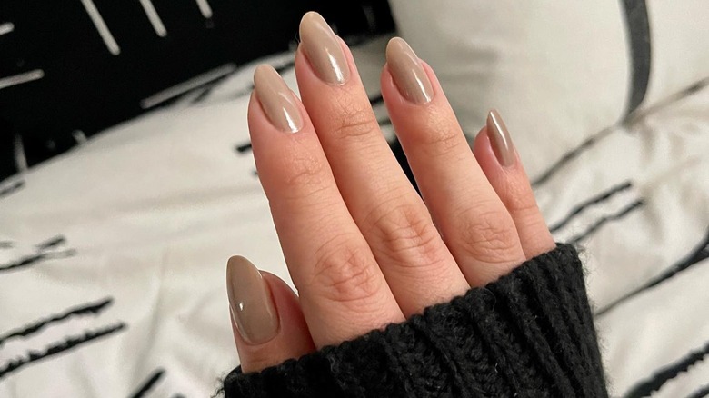 Person with a cool-toned nude manicure