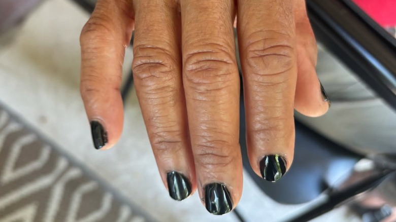 A person wearing black nail polish