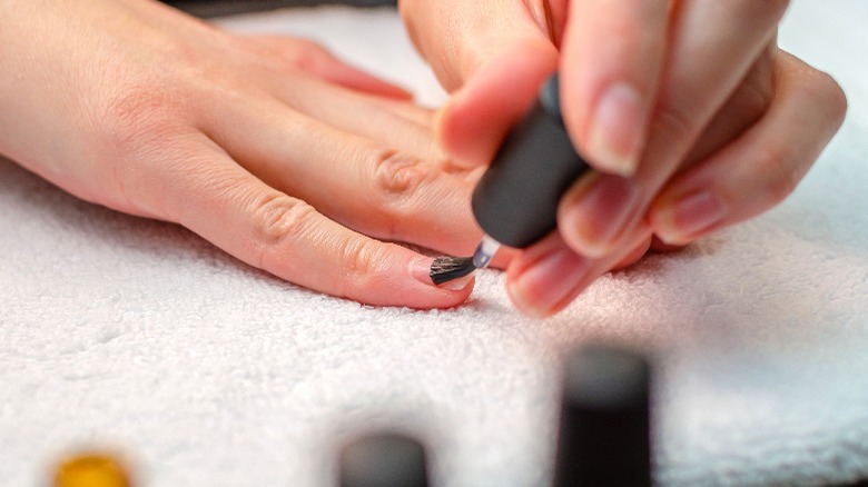 Woman applies nail primer