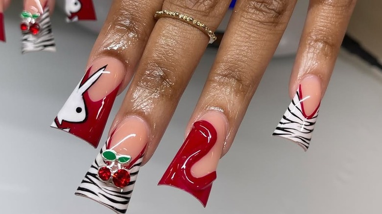 Nails with wide tips that feature red, cherry, zebra print and bunny designs