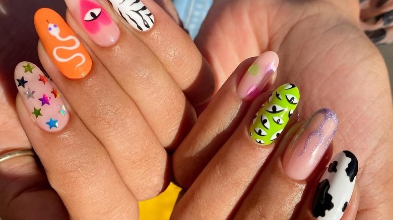 Mismatched nails that feature stars, a snake, eyes, zebra print, hearts and flames