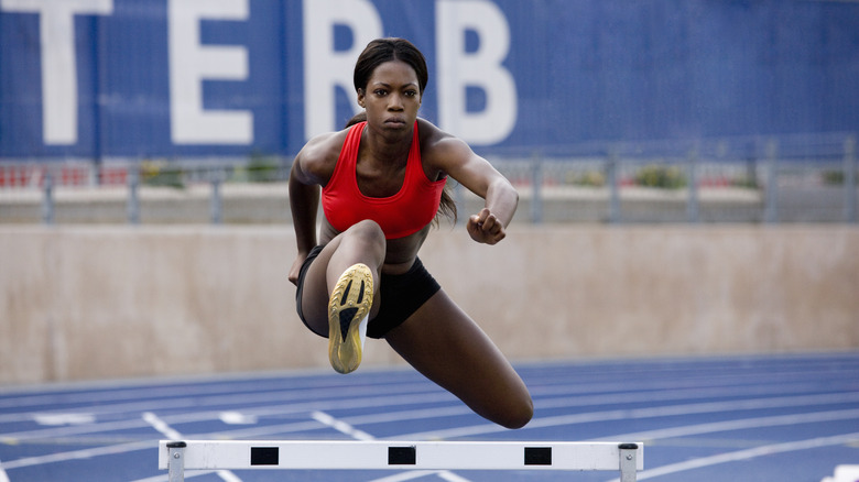 Woman jumping on track field