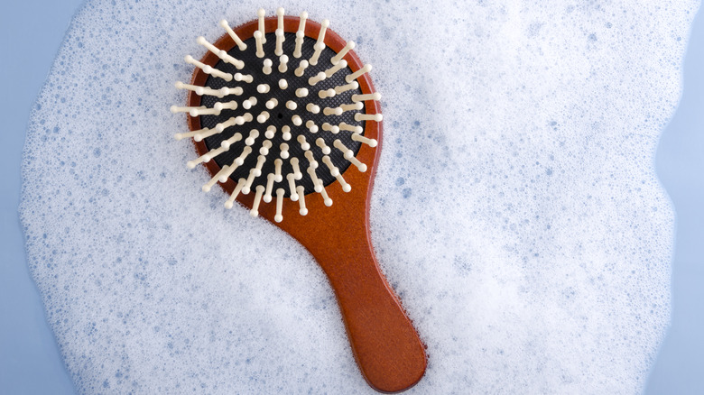 A hairbrush surrounded with suds