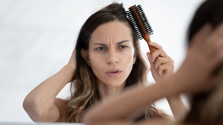 A woman having a hard time using her hairbrush