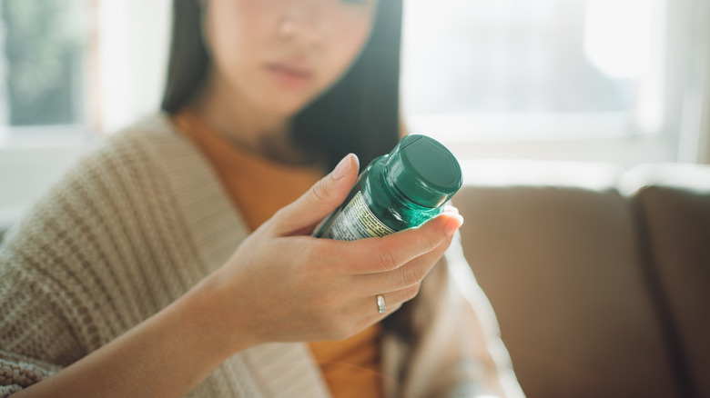 Woman looking at a pill bottle