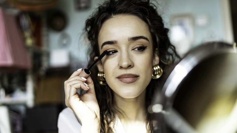 Woman applying mascara