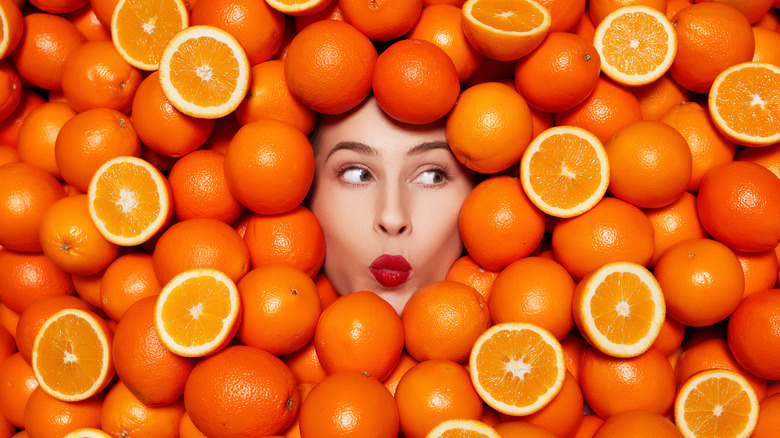 woman surrounded by oranges