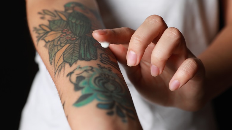 Person applying cream to tattoo 