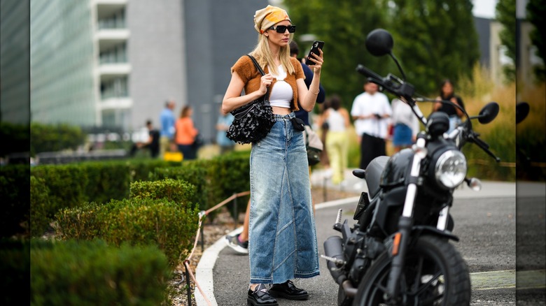 A woman wearing a denim maxi skirt 