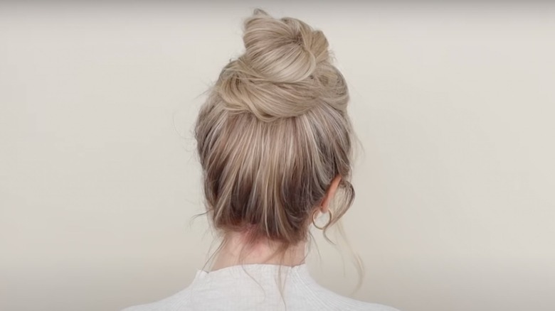 Back view of woman with a messy bun and blond hair