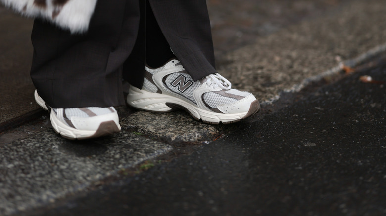 A streetwear close up shot of a woman's white New Balance sneakers