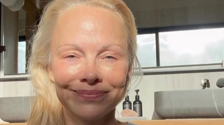 Pamela Anderson applying her skincare